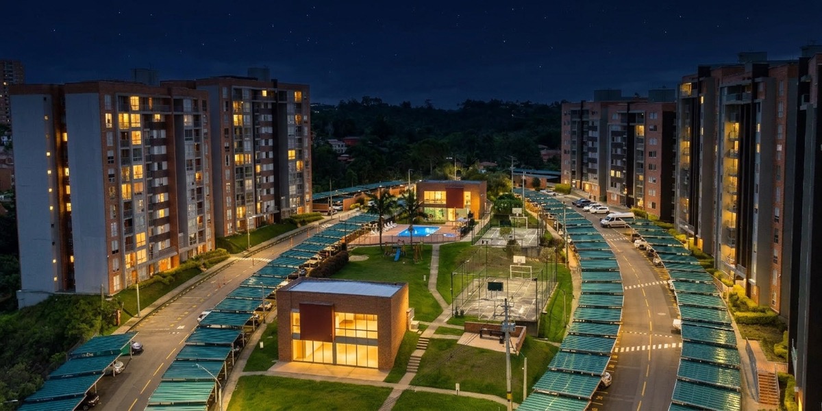 Vista aérea nocturna de un conjunto residencial con parqueadero preparado para cargadores de vehículos eléctricos en Envigado, Antioquia